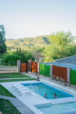 a swimming pool in a backyard with two people in it at Complejo Montana in Potrero de Garay