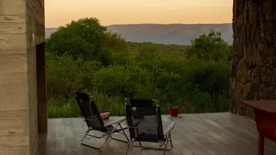 two chairs on a porch with a view of the mountains at Merlín Art Lodge in Atos Pampa