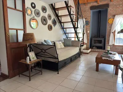 a living room with a couch and a spiral staircase at Shamrock House - Casa de Vacaciones en Merlo, San Luis in Merlo