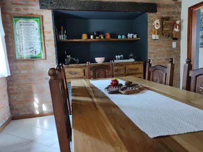 a dining room with a wooden table and a dining room gmaxwell gmaxwell gmaxwell at Shamrock House - Casa de Vacaciones en Merlo, San Luis in Merlo