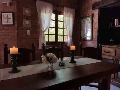 a dining room table with two candles and a window at Shamrock House - Casa de Vacaciones en Merlo, San Luis in Merlo