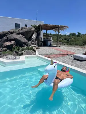 a man is laying in an inflatablelatable unicorn in a swimming pool at Finca Río Secreto in Taninga