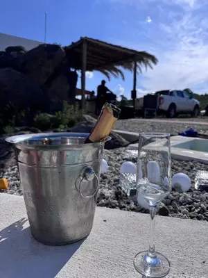 a bucket with a wine bottle in it next to a glass at Finca Río Secreto in Taninga