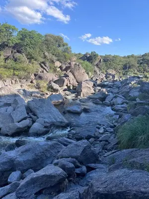 a river with rocks and trees in the background at Finca Río Secreto in Taninga