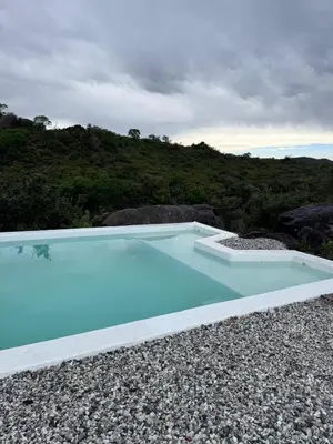 a large blue swimming pool on top of a hill at Finca Río Secreto in Taninga