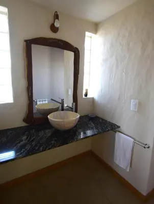 a bathroom with a sink and a large mirror at Las Calandrias in Los Reartes