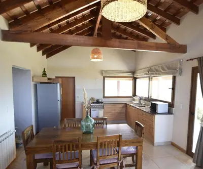 a kitchen with a wooden table and a dining room at Las Calandrias in Los Reartes
