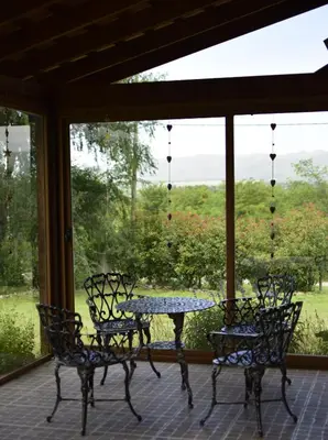 a table and chairs on a screened porch with a view at Las Calandrias in Los Reartes
