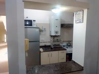 a small kitchen with a refrigerator and a stove at Alojamiento Centro de Carlos Paz in Villa Carlos Paz