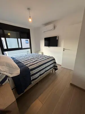 a bedroom with a bed and a flat screen tv at Las Pircas Housing in Alta Gracia