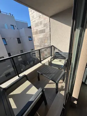 a balcony with two chairs and a bench on a building at Las Pircas Housing in Alta Gracia