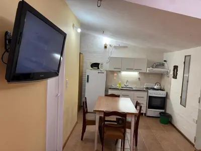 a kitchen with a table and a television on a wall at La Quinta in Villa Carlos Paz
