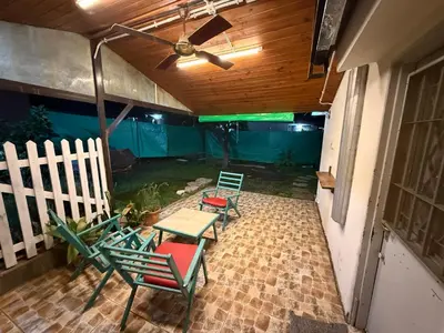 a patio with four chairs and a ceiling fan at La Quinta in Villa Carlos Paz