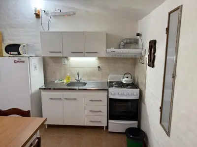 a small kitchen with a stove and a sink at La Quinta in Villa Carlos Paz