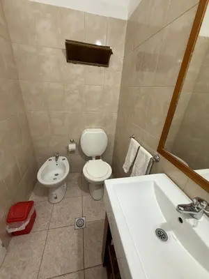 a bathroom with a white toilet and a sink at La Quinta in Villa Carlos Paz