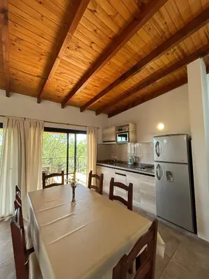a dining room with a table and a refrigerator at Refugio de las Nubes in Las Rabonas