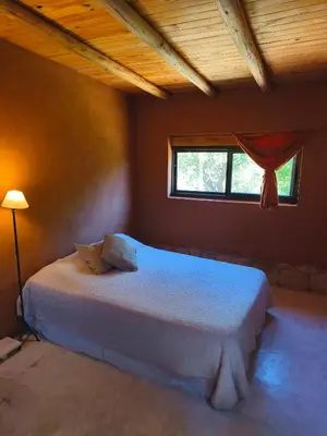 a bedroom with a white bed with a window at Casas Serranas in La Bajada