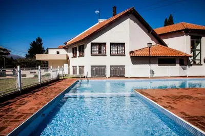 a house with a swimming pool in front of a house at Hotel Sol y Luna in Merlo