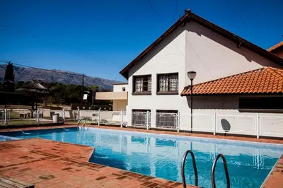 a house with a swimming pool in front of a house at Hotel Sol y Luna in Merlo