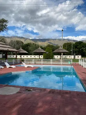 a swimming pool with blue water and mountains in the background at Hotel Sol y Luna in Merlo