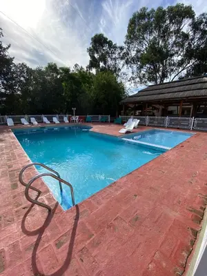 a swimming pool with chairs and a bench next to it at Hotel Sol y Luna in Merlo