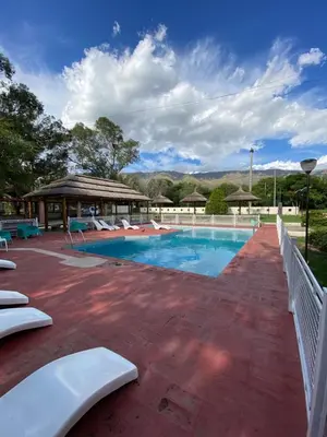 a swimming pool with chairs and a pavilion at Hotel Sol y Luna in Merlo