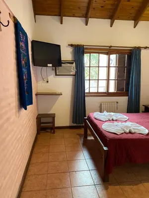 a room with a table and a tv on the wall at Hotel Sol y Luna in Merlo