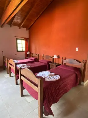 a row of beds in a room with red walls at Hotel Sol y Luna in Merlo