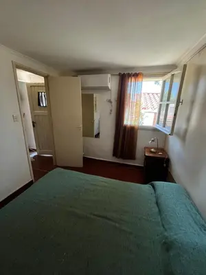 a bedroom with a green bed and a window at Cabaña AGU en Cabañas María in Villa Carlos Paz