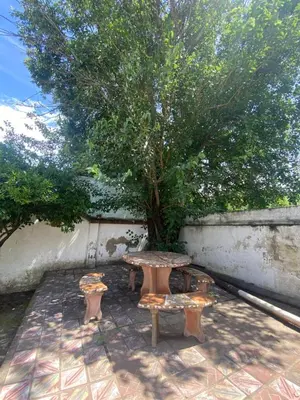 a picnic table and bench next to a tree at Cabaña AGU en Cabañas María in Villa Carlos Paz