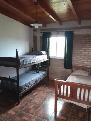 a room with three bunk beds and a window at La casa de Daniel in Villa Santa Cruz del Lago