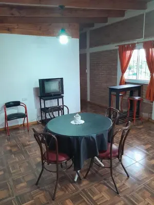 a dining room with a table and chairs and a tv at La casa de Daniel in Villa Santa Cruz del Lago