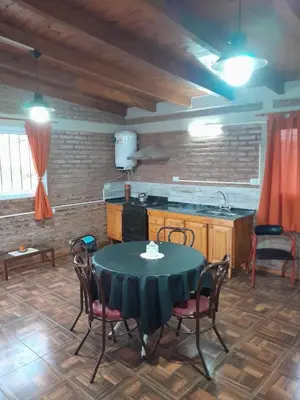 a kitchen with a table with chairs and a sink at La casa de Daniel in Villa Santa Cruz del Lago