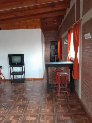 a room with a table and chairs and a television at La casa de Daniel in Villa Santa Cruz del Lago