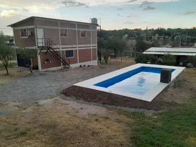 an empty swimming pool in front of a building at La casa de Daniel in Villa Santa Cruz del Lago