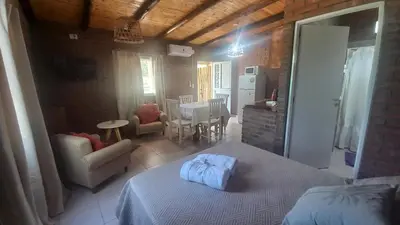 a bedroom with a bed and a kitchen and a dining room at Armonia cabaña de campo- Rincón de Afrodita in San Lorenzo
