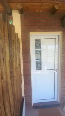 a white door in a brick wall with a window at Armonia cabaña de campo- Rincón de Afrodita in San Lorenzo