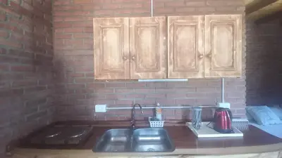 a kitchen counter with a sink and wooden cabinets at Armonia cabaña de campo- Rincón de Afrodita in San Lorenzo
