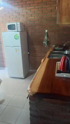 a kitchen with a white refrigerator and a sink at Armonia cabaña de campo- Rincón de Afrodita in San Lorenzo