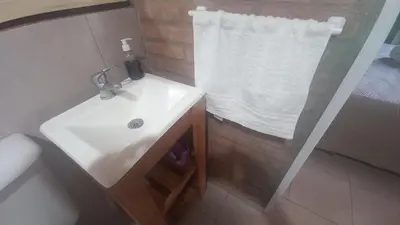 a bathroom with a white sink and a shower at Armonia cabaña de campo- Rincón de Afrodita in San Lorenzo