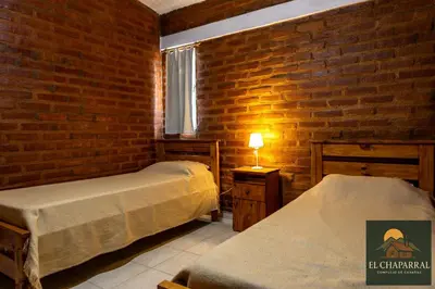 a bedroom with two beds and a brick wall at Cabaña El Chaparral Villa Dolores, Traslasierra 4 in Villa Dolores