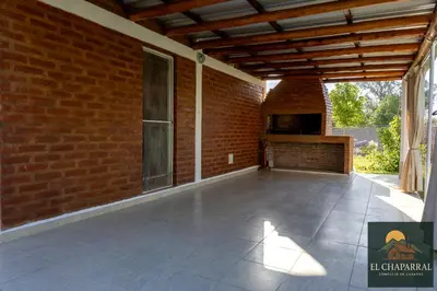 an outdoor patio with a brick wall and a wooden ceiling at Cabaña El Chaparral Villa Dolores, Traslasierra 4 in Villa Dolores