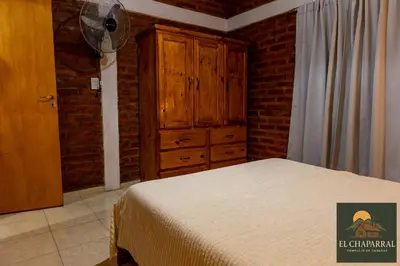 a bedroom with a bed and a wooden cabinet at Cabaña El Chaparral Villa Dolores, Traslasierra 4 in Villa Dolores