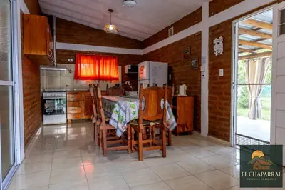 a kitchen with a table and chairs in a room at Cabaña El Chaparral Villa Dolores, Traslasierra 4 in Villa Dolores