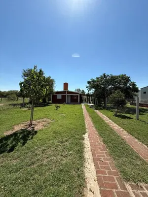 a brick path in a field with a building at Cabaña El Chaparral Villa Dolores, Traslasierra 4 in Villa Dolores