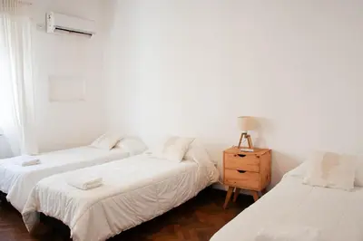 a bedroom with two beds and a night stand at Piso completo en el centro de cordoba, muy amplio especial para familias in Cordoba