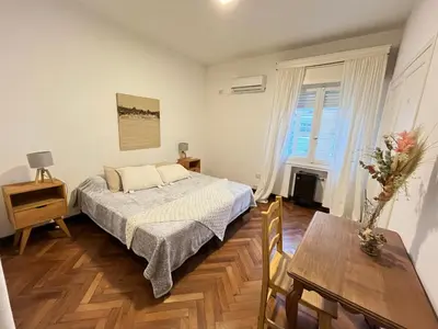 a bedroom with a bed and a table in it at Piso completo en el centro de cordoba, muy amplio especial para familias in Cordoba