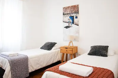 two beds in a room with white walls at Piso completo en el centro de cordoba, muy amplio especial para familias in Cordoba