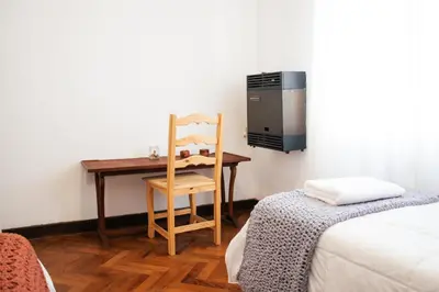 a room with a desk and a chair next to a bed at Piso completo en el centro de cordoba, muy amplio especial para familias in Cordoba
