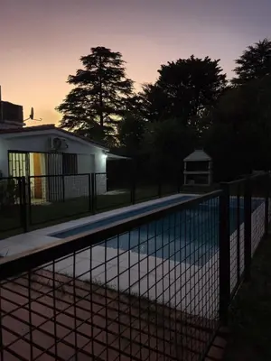 a fence with a swimming pool in front of a house at Don EDELMI 2 in Cordoba